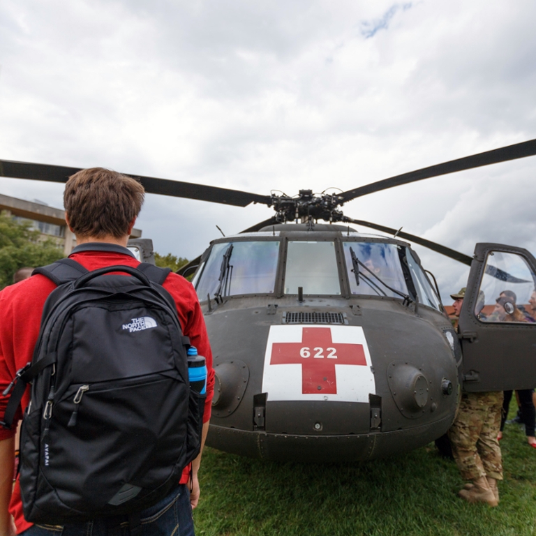 A student looks at a National Guard rescue helicopter. 