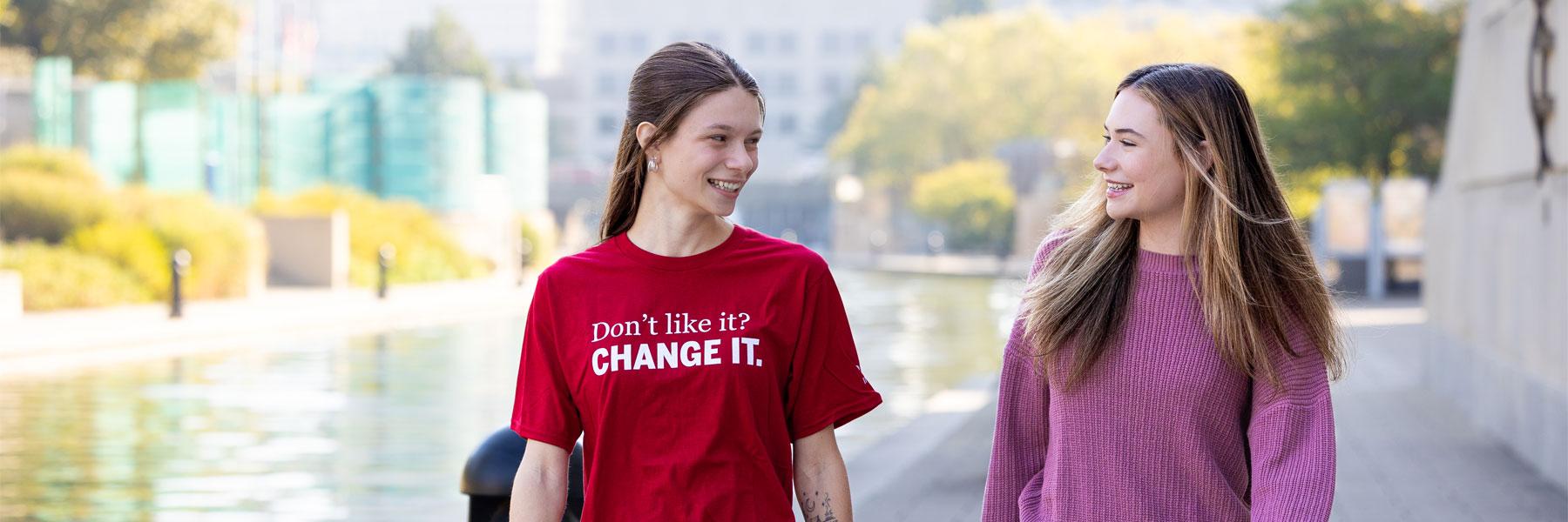 Two students walking along a canal.