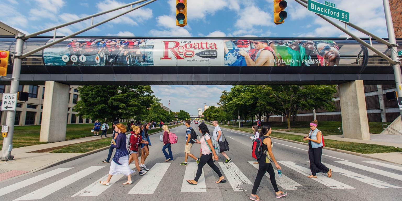 IUPUI students cross the road on campus.