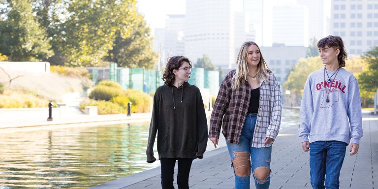 Three students walking along the canal in downtown Indianapolis.