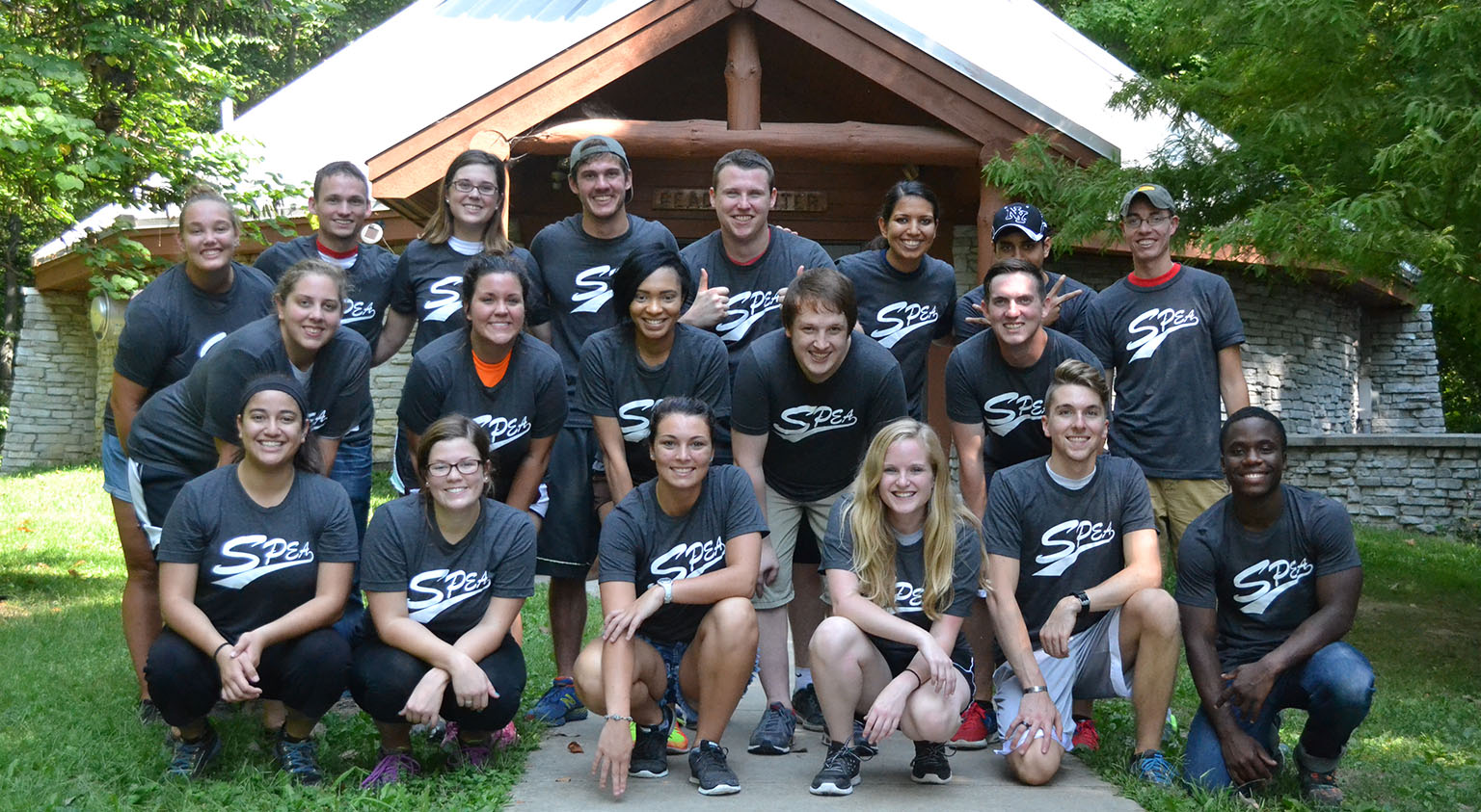 A SPEA student organization poses as a group in front of a cabin. 